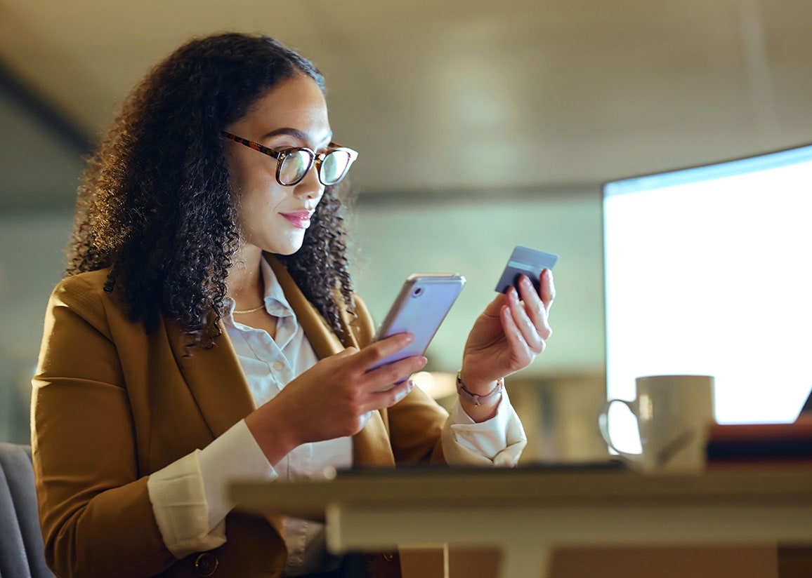 African-American businesswoman using credit card and smartphone to make purchase