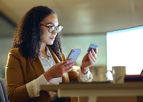 African-American businesswoman using credit card and smartphone to make purchase