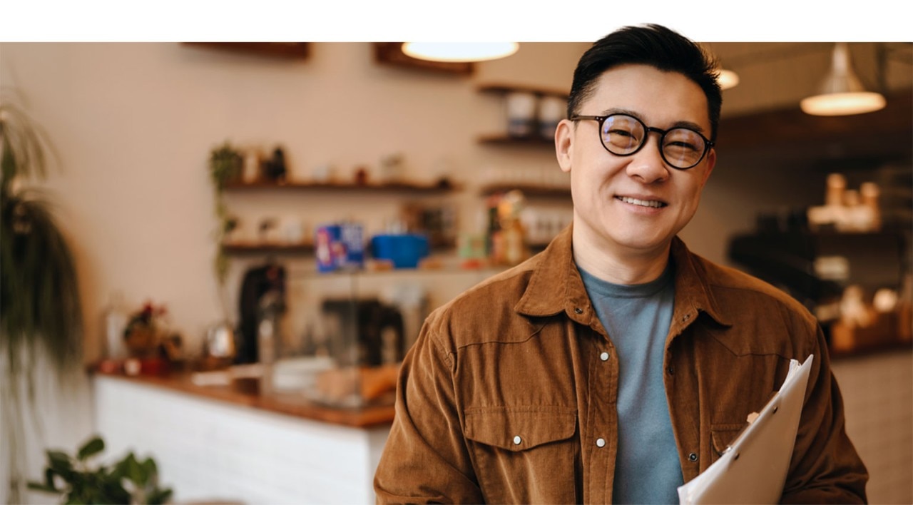 Smiling Asian-American business owner standing in a shop