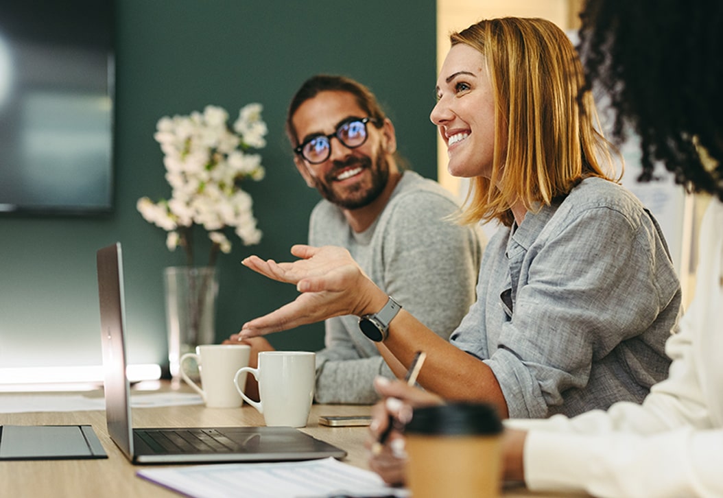 Smiling colleagues conversing at a conference table