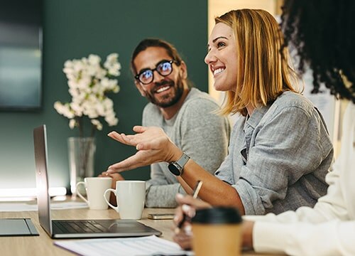 Smiling colleagues conversing at a conference table