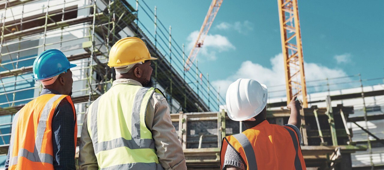 African-American workers assessing progress at a building construction site