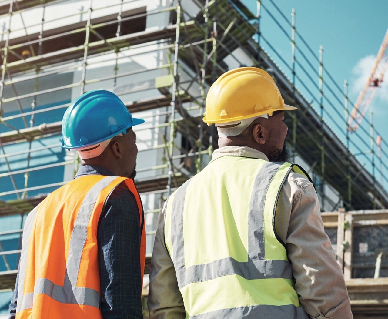 African-American workers assessing progress at a building construction site