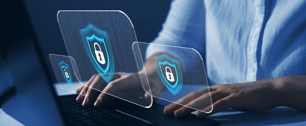 A person working on a laptop with three lock screen images in the foreground