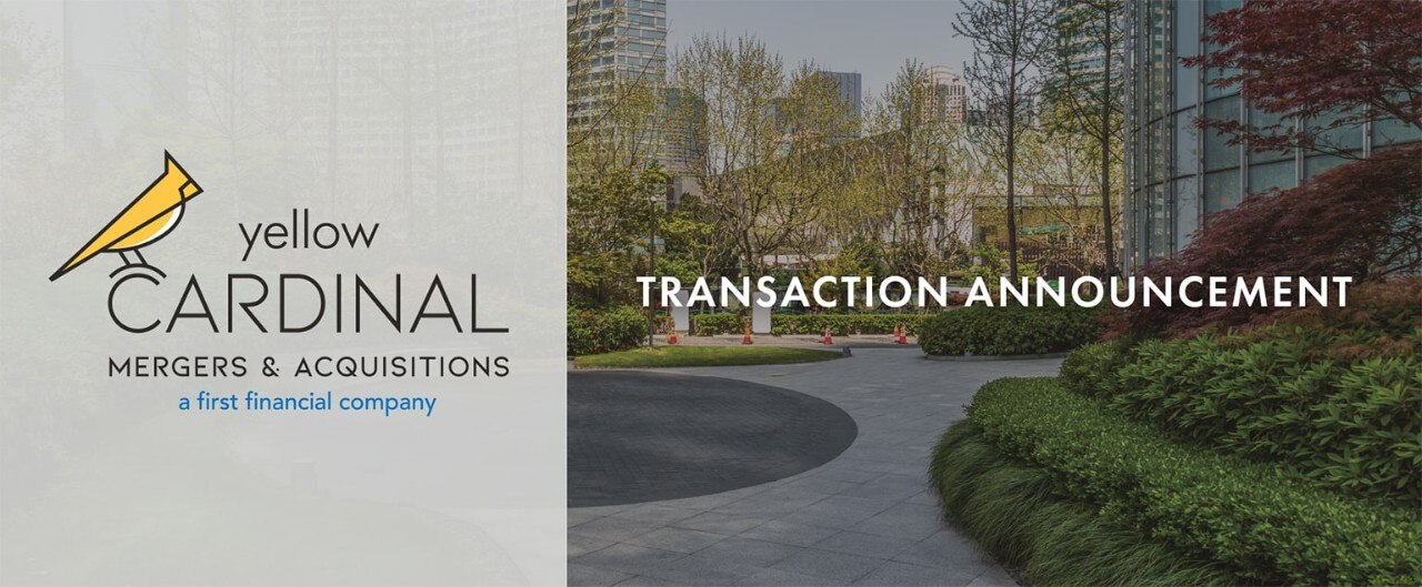 Yellow Cardinal Mergers & Acquisitions logo above a freshly landscaped office property