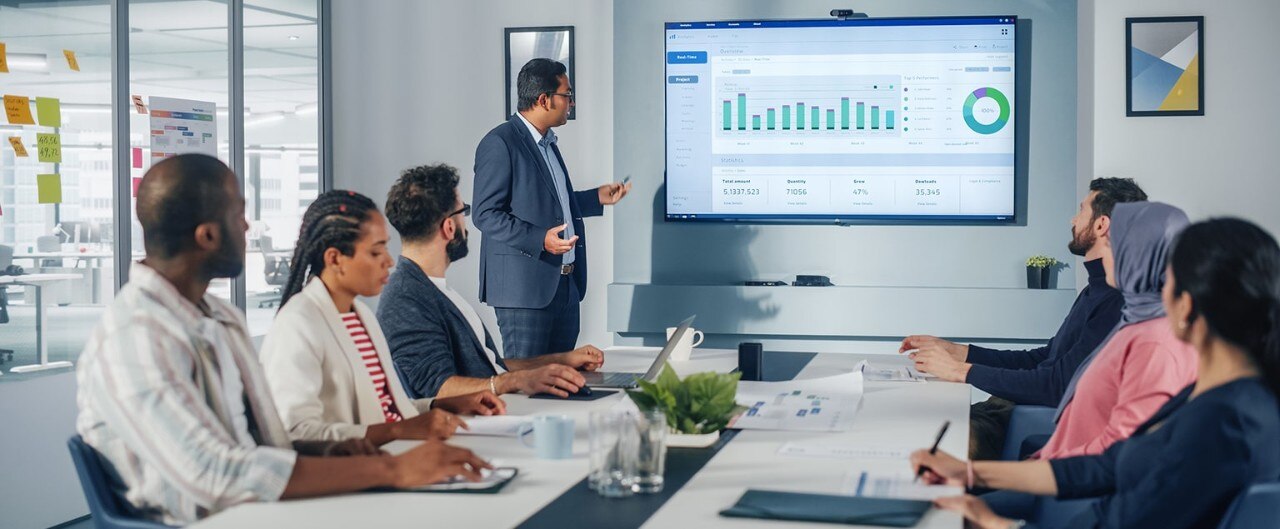 Business team reviewing finances on large screen in conference room