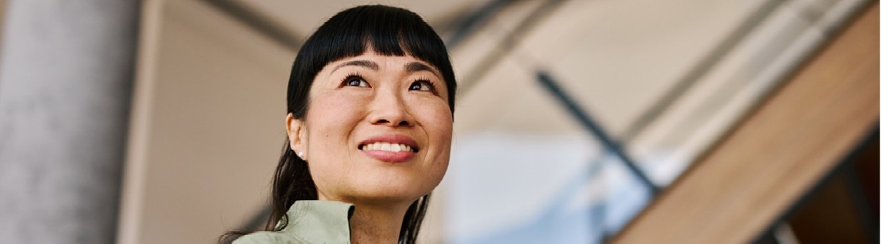 A close-up portrait captures a smiling woman looking slightly upward.
