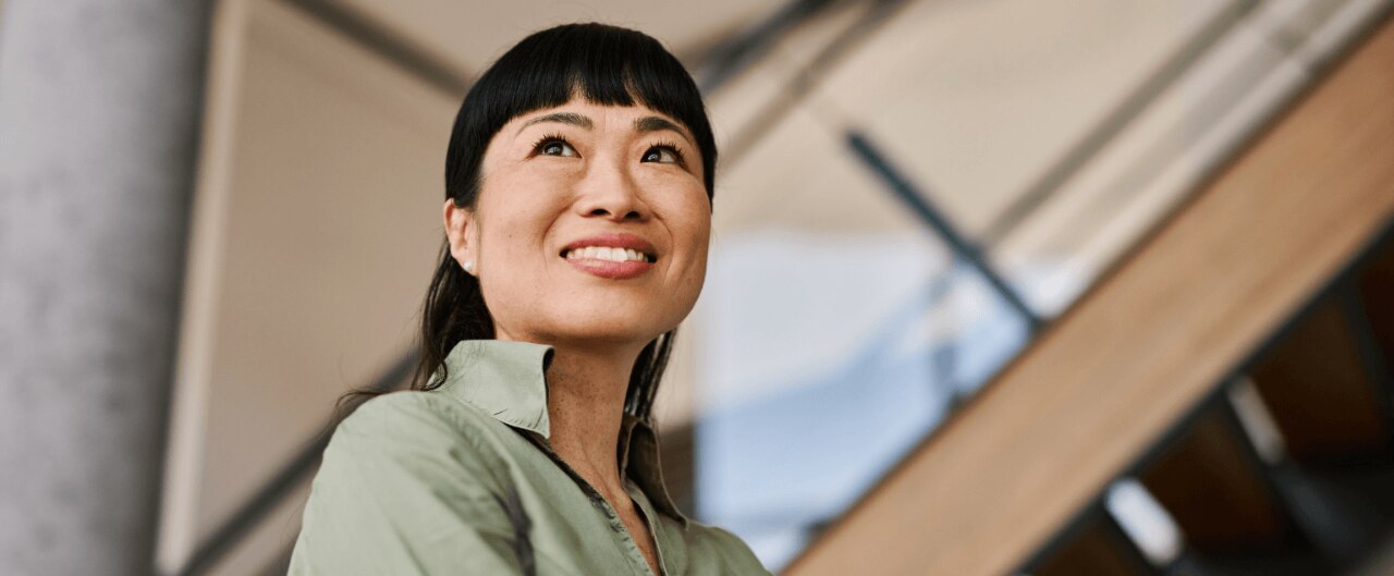 A close-up portrait captures a smiling woman looking slightly upward.