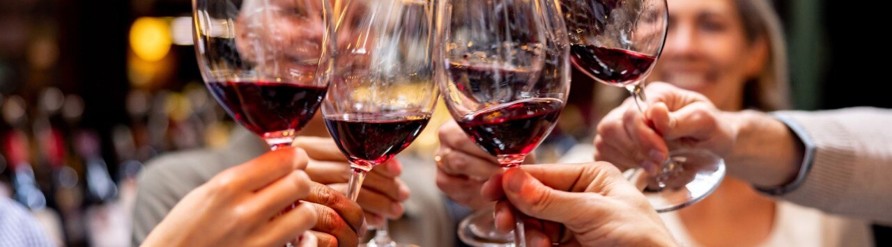 Group of friends toasting with glasses of red wine