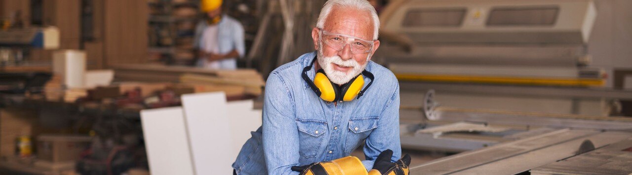 Older small business owner smiling in a carpentry warehouse
