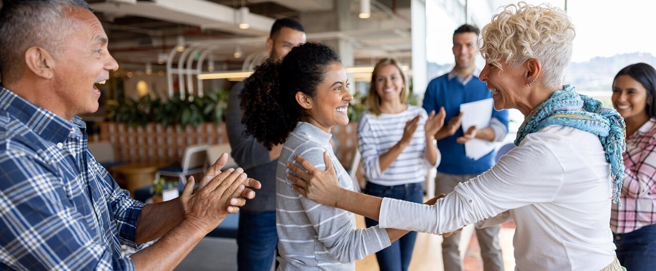 Employees clapping and being recognized by manager