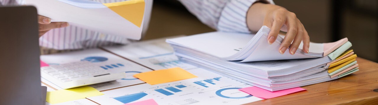 Female business owner reviewing stack of organized financial files