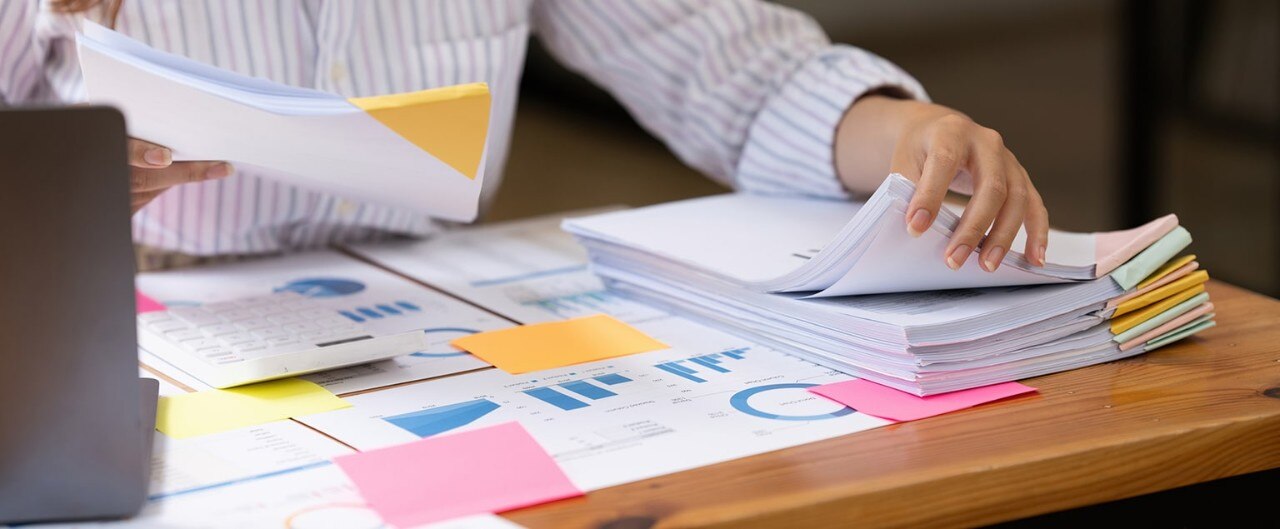 Female business owner reviewing stack of organized financial files