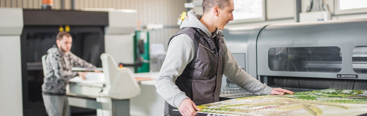 Small business owners using machinery to cut glass