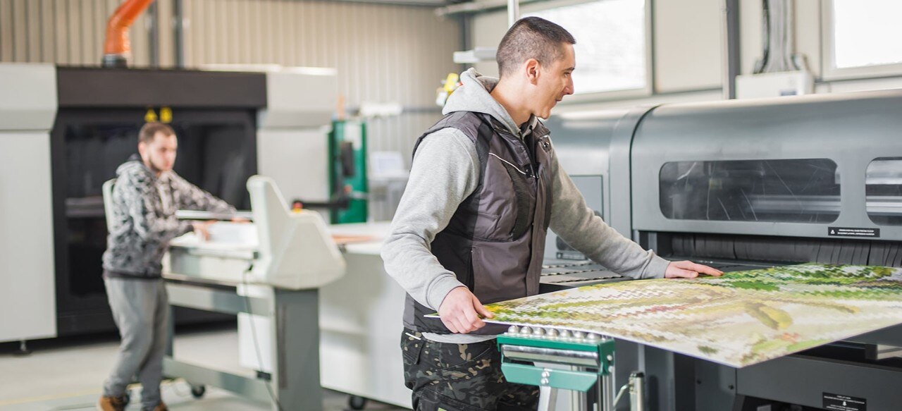 Small business owners using machinery to cut glass