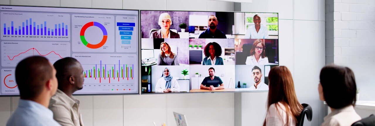 Businesspeople attending a video conference and hybrid presentation with international colleagues