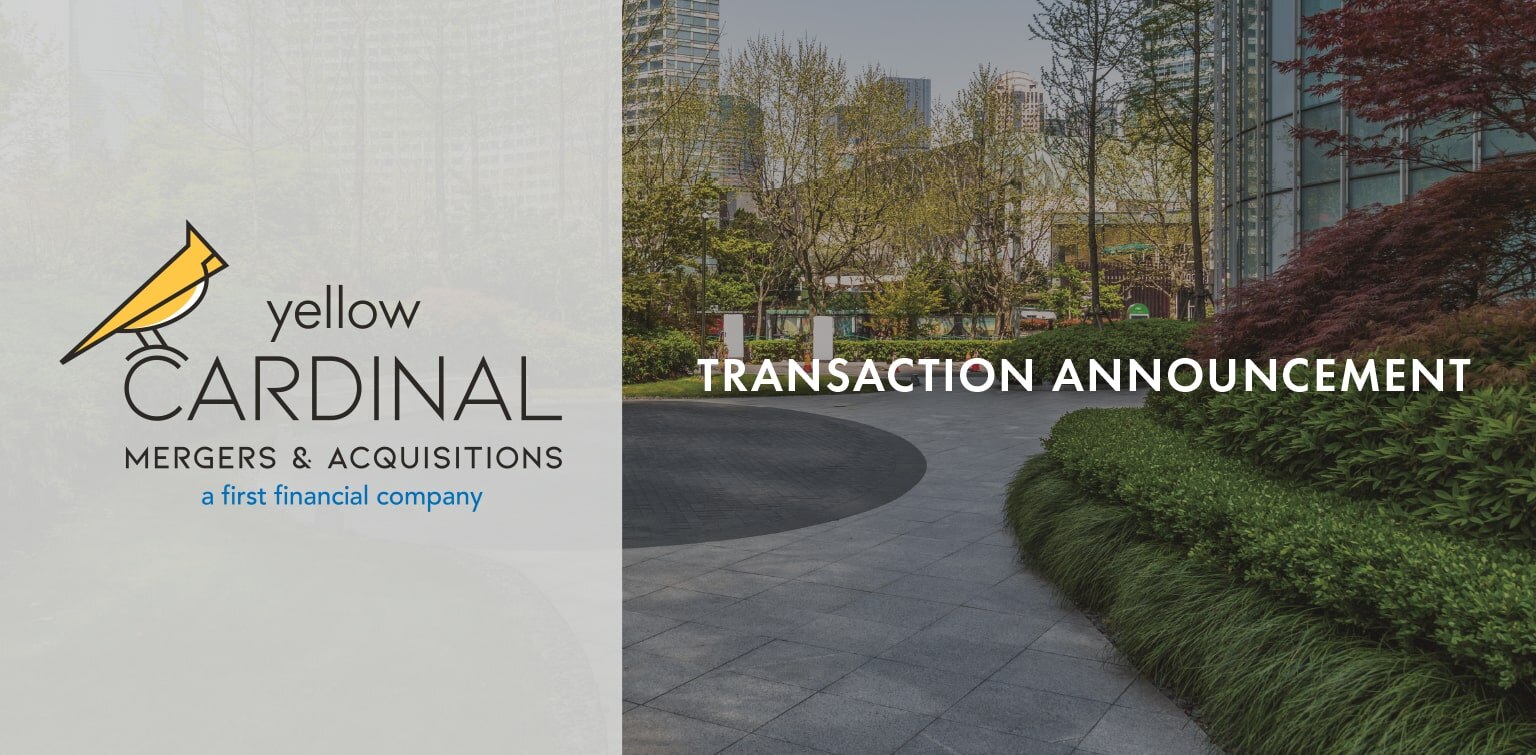 Yellow Cardinal Mergers & Acquisitions logo above a freshly landscaped office property