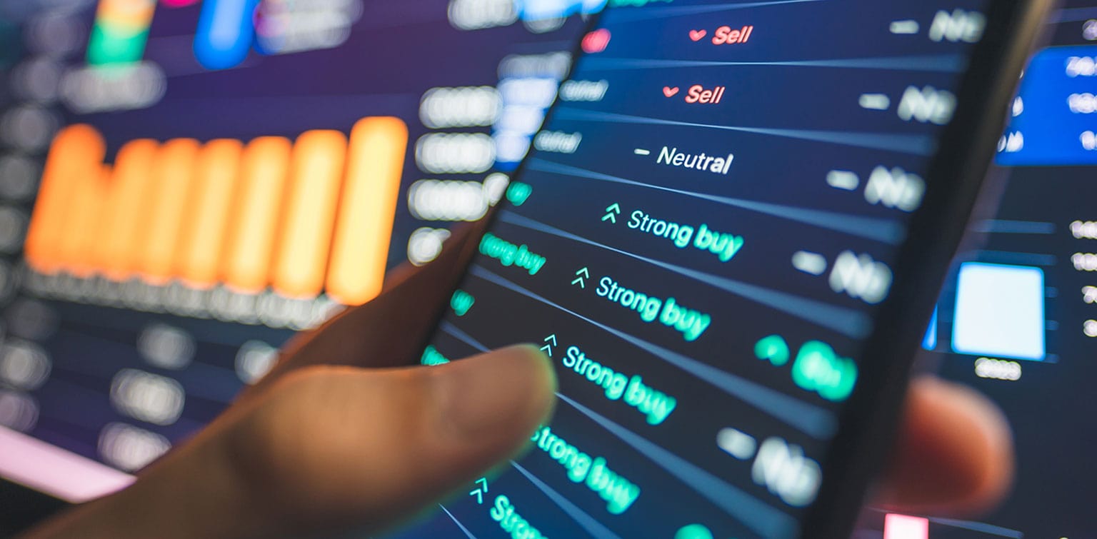 Person's hand holding a smartphone displaying positive stock data