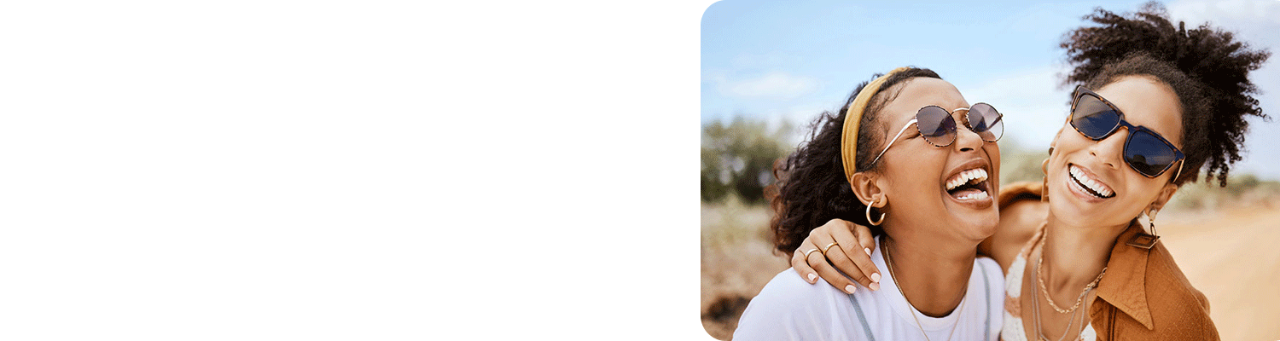 Two young African-American women smiling and hugging