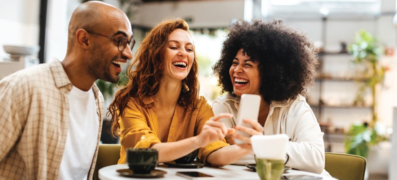 A group of people enjoying each other's company at a coffee shop. 