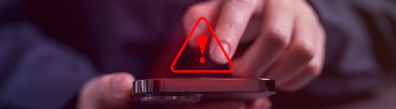 man on his phone with a red exclamation mark above it