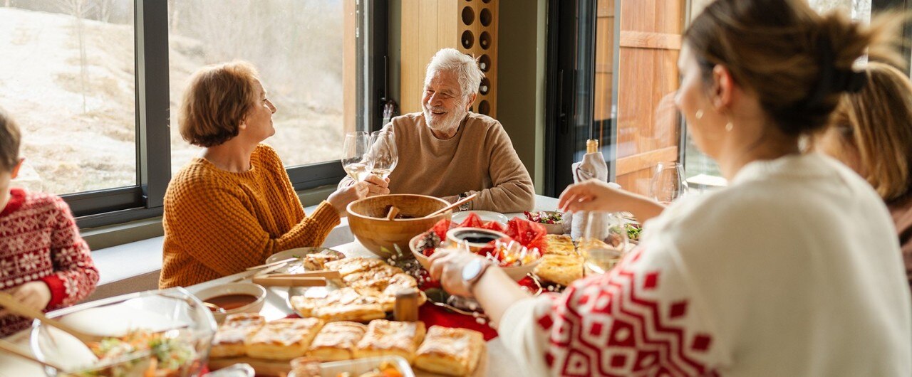 Senior couple and family members gathered around dinner table