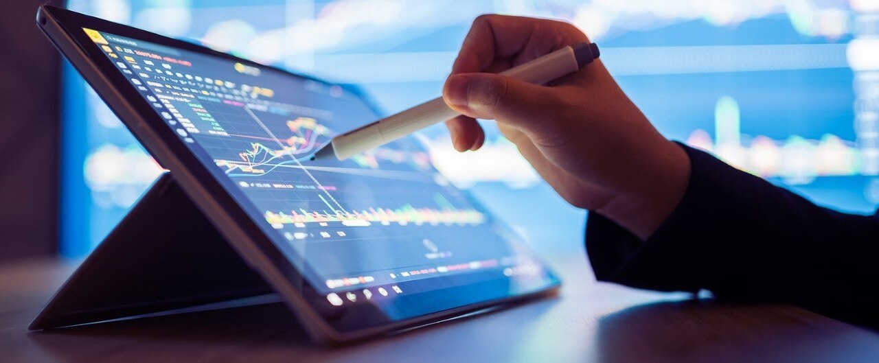 Financial professional reviewing stock data on tablet computer