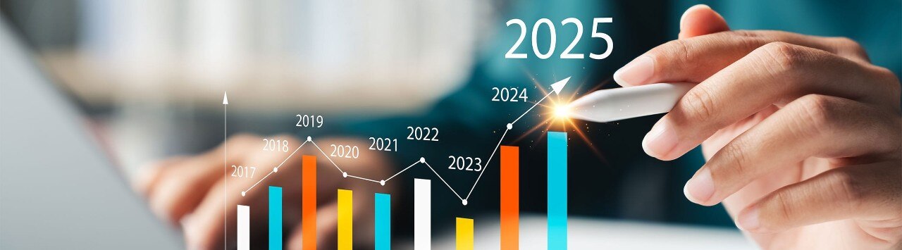 A person's hands using a laptop with an upward trending year-over-year financial graph