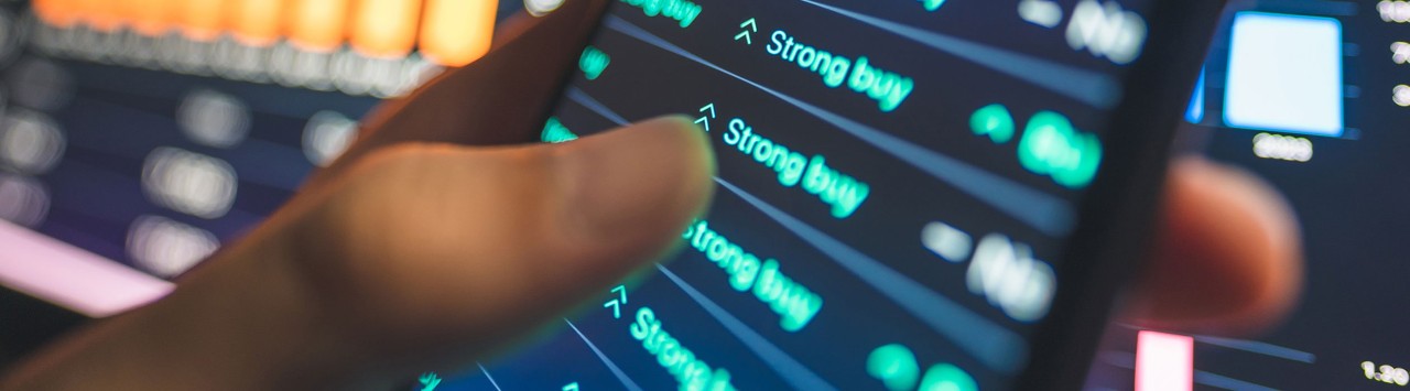 Person's hand holding a smartphone displaying positive stock data