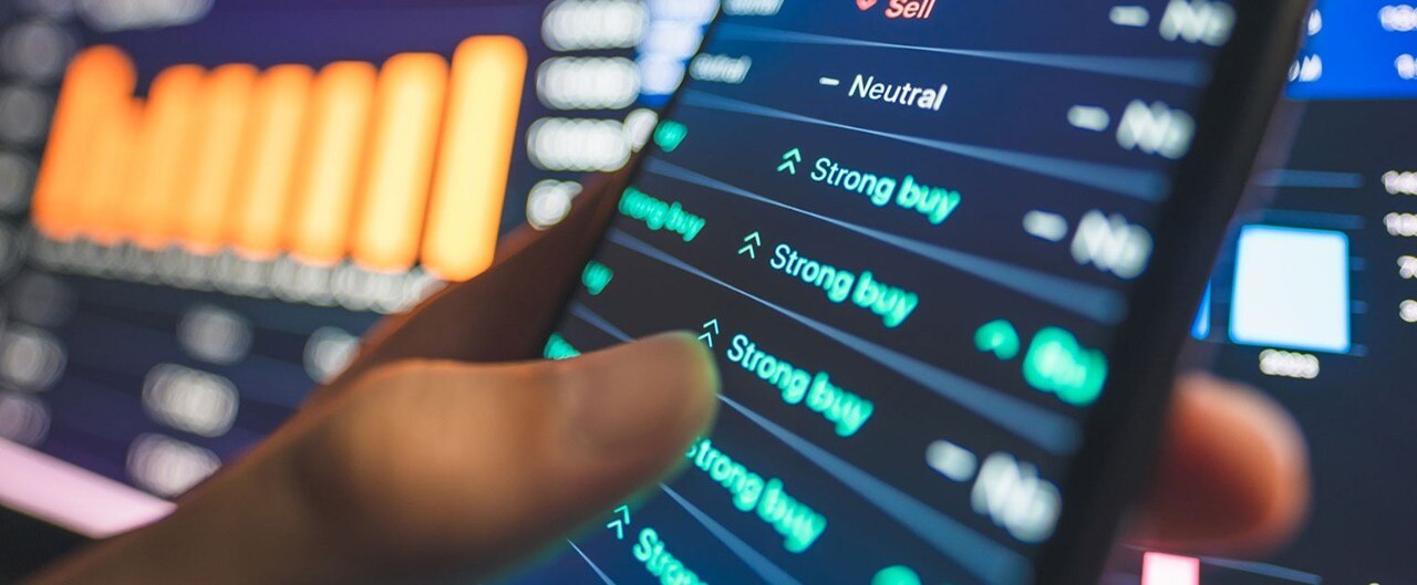 Person's hand holding a smartphone displaying positive stock data