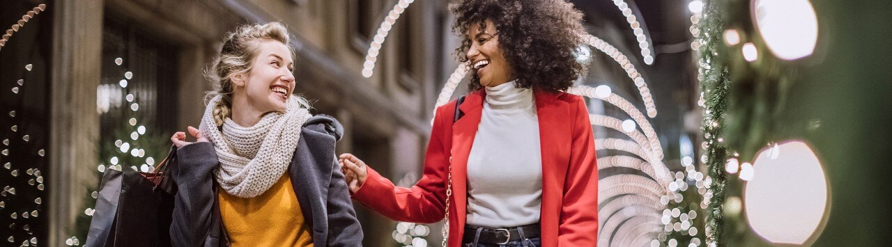 Happy Caucasian and African-American women shopping during the holidays