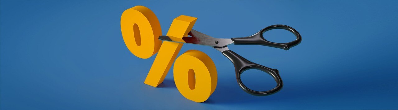 A pair of scissors cutting a yellow percentage sign
