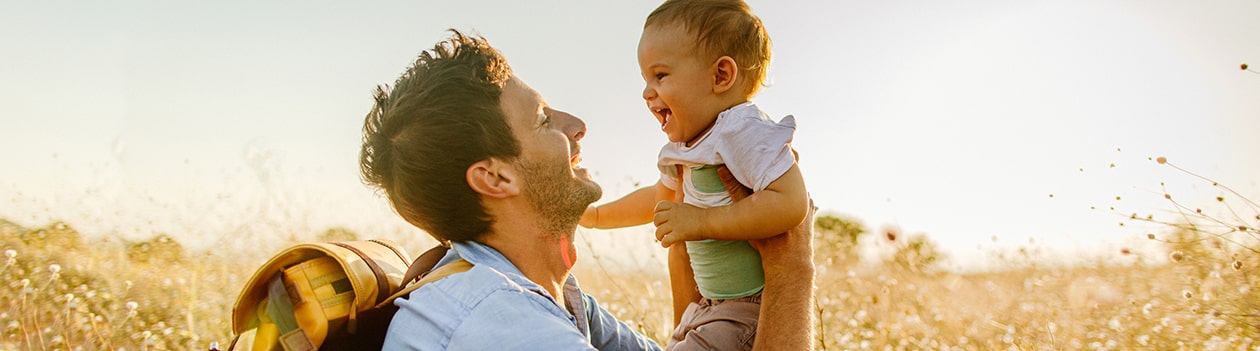 Father with backpack holding his young child