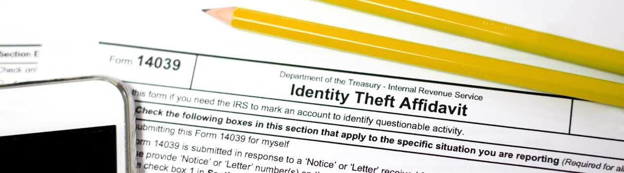Smartphone and pencils on top of Identity Theft Affidavit form