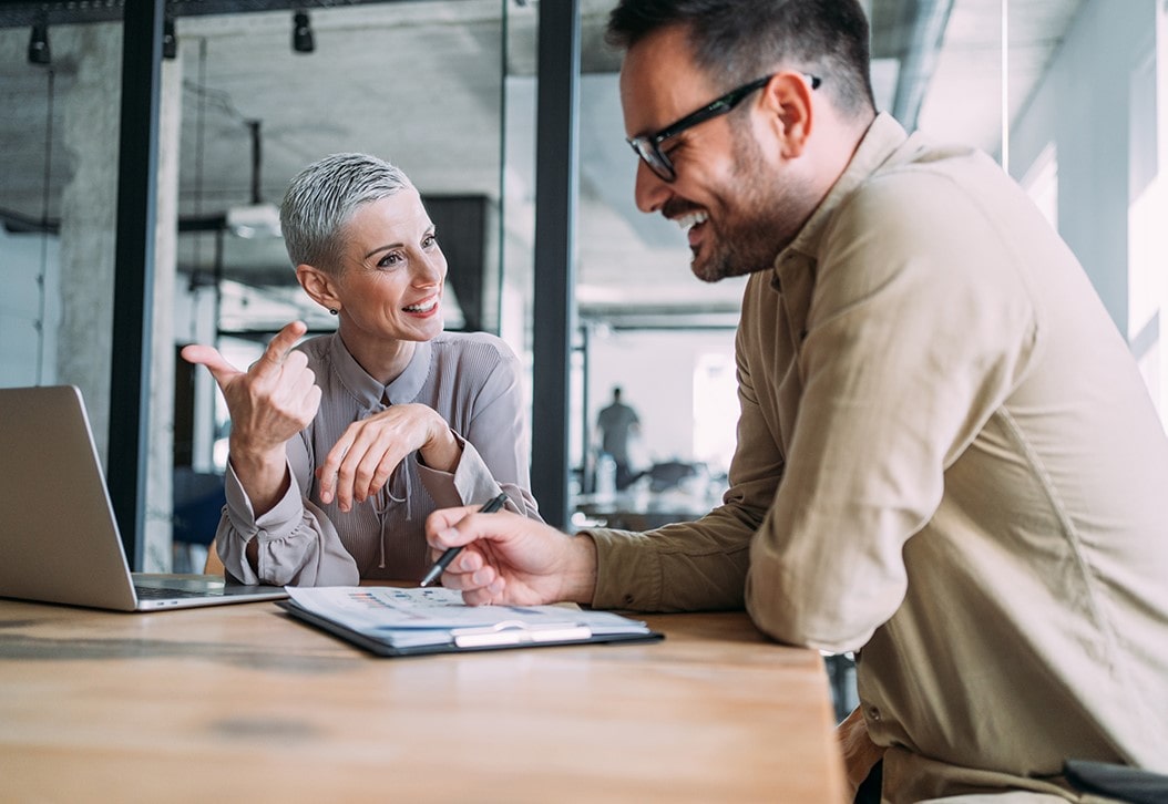 Smiling colleagues reviewing documents in conference room
