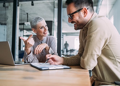 Smiling colleagues reviewing documents in conference room