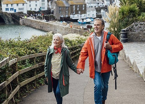 Senior couple holding hands and walking through a European city